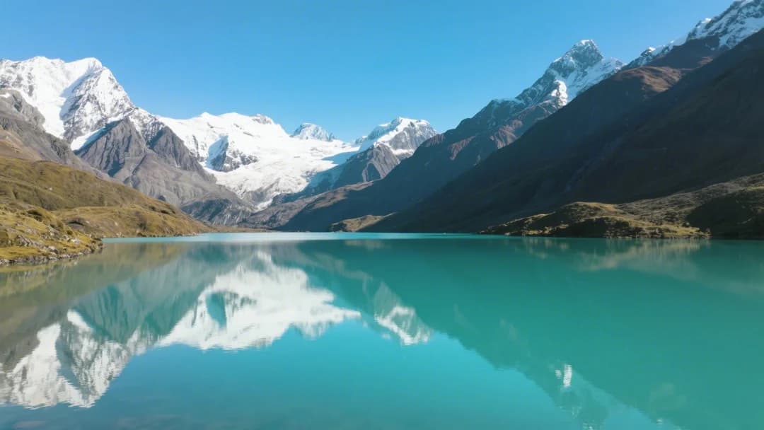 Vista panorámica de la laguna Singrenacocha con aguas turquesas y montañas nevadas de fondo en Cusco, Perú.